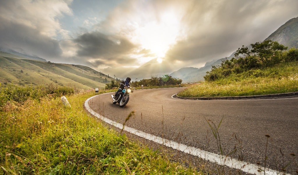 Motorcycle driver riding in Dolomite pass, Italy, south Europe.