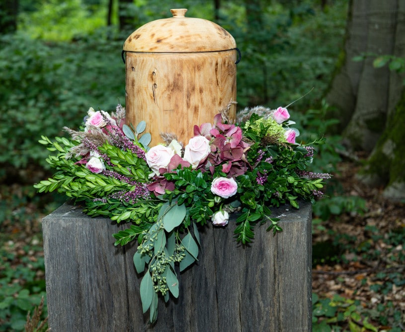 Holzurne und Blumenschmuck, Waldbestattung